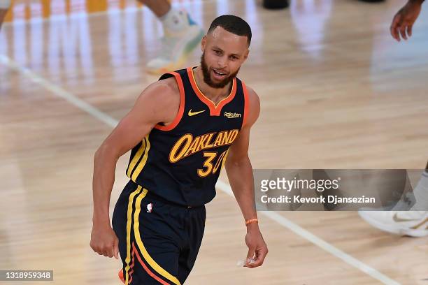 Stephen Curry of the Golden State Warriors reacts after hitting a three-point shot during the final seconds of the first half of an NBA Tournament...