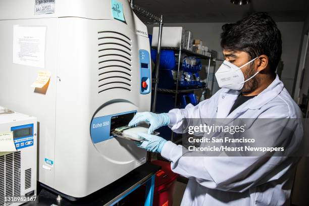 Karan Bhatt, a research associate at Chan Zuckerberg Biohub, places a bottom microplane into Echo acoustic liquid handler for genomic sequencing in...