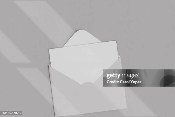 opened brown envelope with blank card on grey background with shadows - envelope stock pictures, royalty-free photos & images