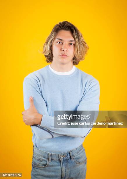 blond man with crossed arms yellow background - man studio shot stock pictures, royalty-free photos & images