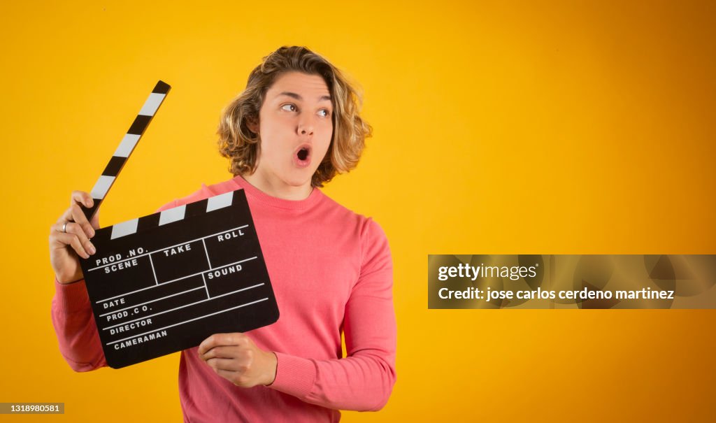 Blond man clapperboard, smiling, movies