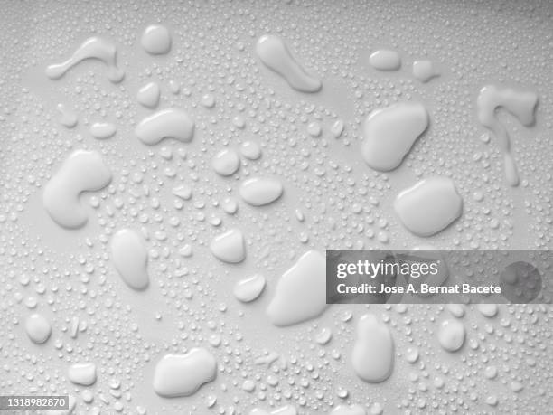 full frame of drops and splashes of water on a white background. - water puddle stock pictures, royalty-free photos & images