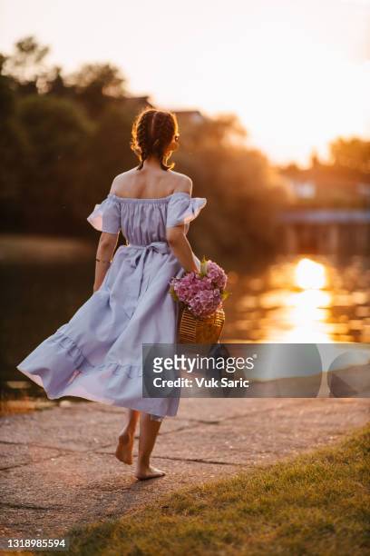 woman walking at sunset by the river - fishtail braid stock pictures, royalty-free photos & images