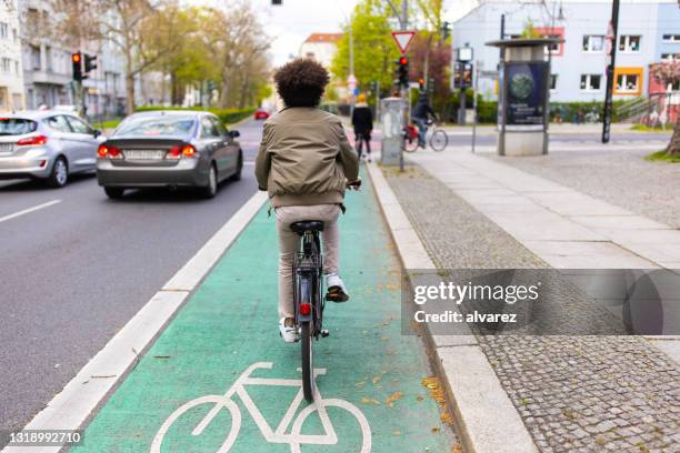 fietser in stadsverkeer dat het fietspad gebruikt - on the move rear view stockfoto's en -beelden