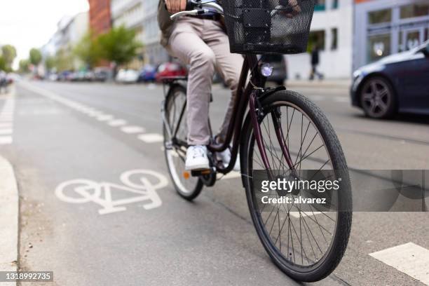mann radelt auf radweg in der stadt - bicycle lane stock-fotos und bilder