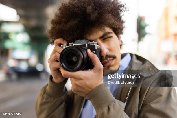 fotografo creativo mediorientale che scatta foto - macchina fotografica digitale foto e immagini stock