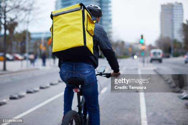 ein junger lieferfahrer in einem fahrrad. - bike messenger stock-fotos und bilder