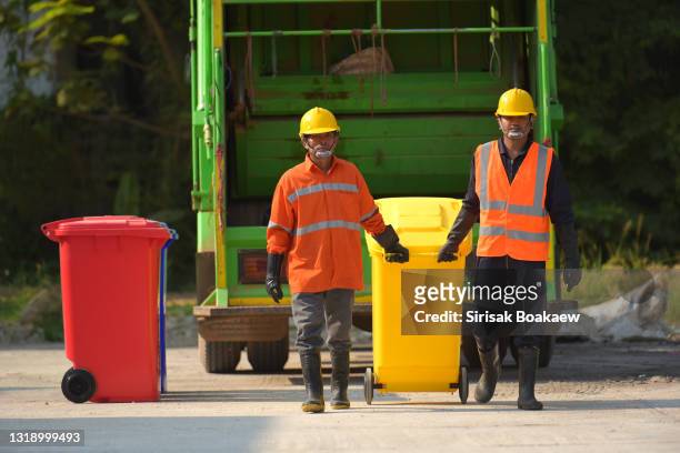 garbage collector worker of urban municipal recycling garbage collector truck loading waste - garbage truck driving stock pictures, royalty-free photos & images