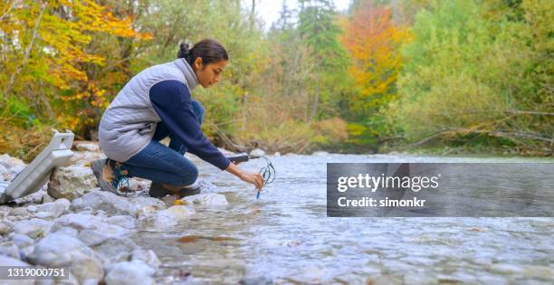 vrouwelijke bioloog die de zuurstofniveaus in de rivier test - measurement stockfoto's en -beelden