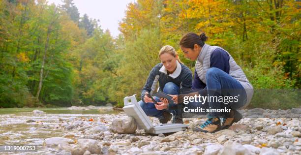 female biologists examining quality of water in river - scientist full length stock pictures, royalty-free photos & images