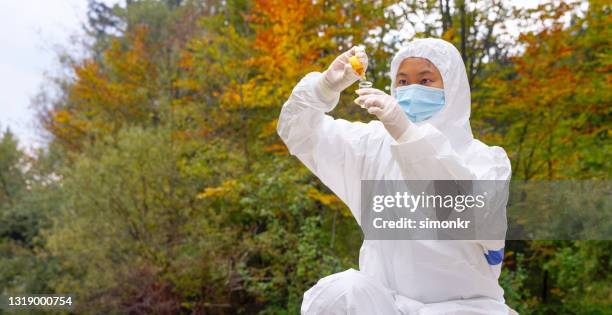 biologiste femelle ajoutant le réapprovisionnement dans un flacon avec l’échantillon d’eau - prélèvement à tester photos et images de collection