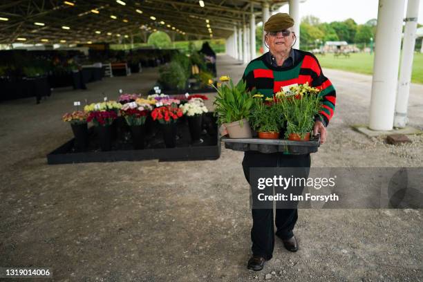 Man carries a tray of flowers as he prepares his display on the first day of the Spring Essentials Flower Show at the Great Yorkshire Showground on...