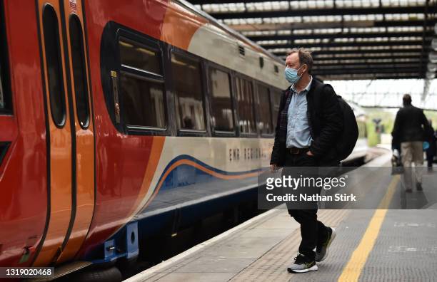 Man makes his way onto a East Midlands Trains at Stoke-on-Trent Train Station on May 20, 2021 in Stoke, England. The British government has created a...