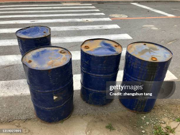 dented and rusty blue colored oil barrel - oil drum stock pictures, royalty-free photos & images