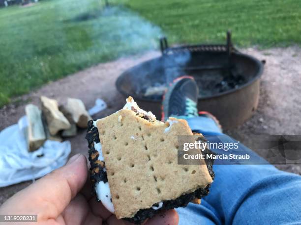 eating s'mores at a campfire - smore stock-fotos und bilder