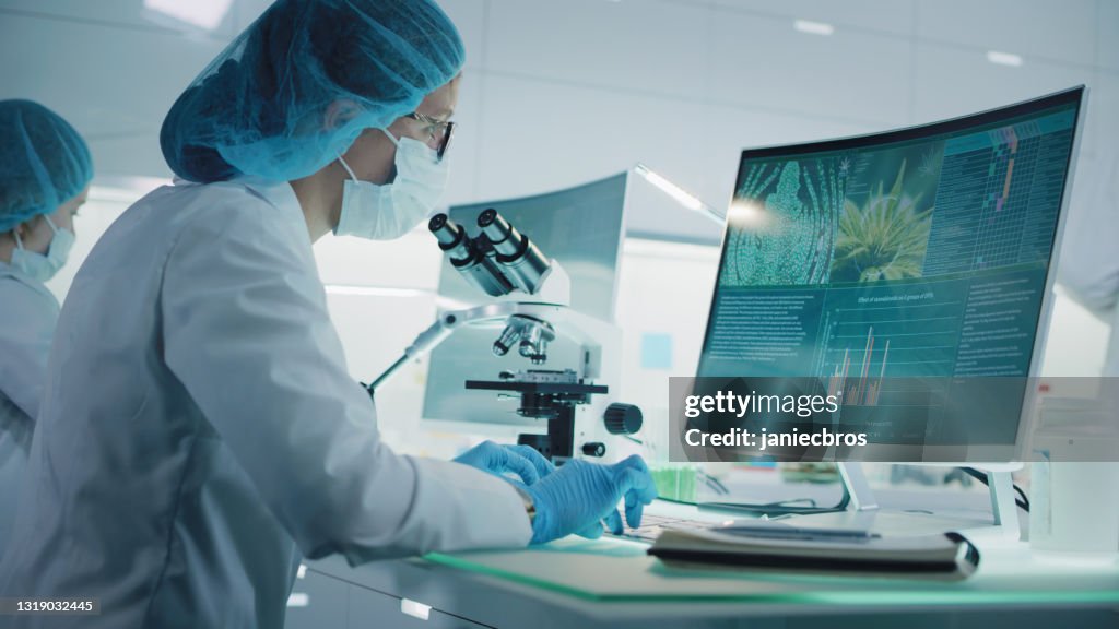 Female scientist testing medical marijuana. Charts and models on computer screens. Modern laboratory interior