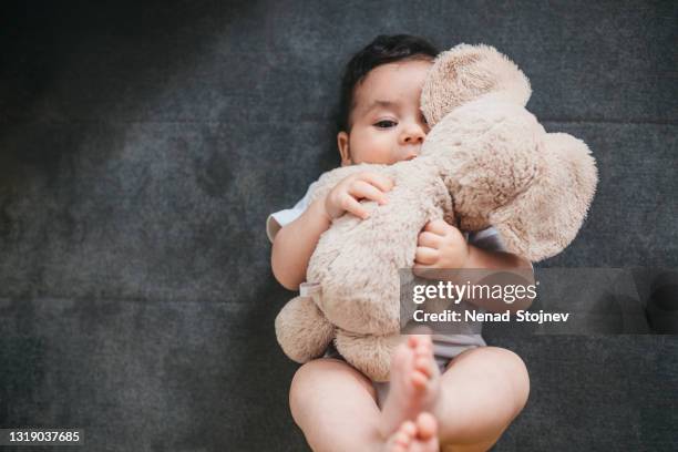 chéri caucasienne avec un ours de nounours - bébé doudou photos et images de collection