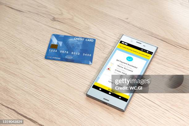 paying bills on the phone, home finances - credit card mockup stock-fotos und bilder