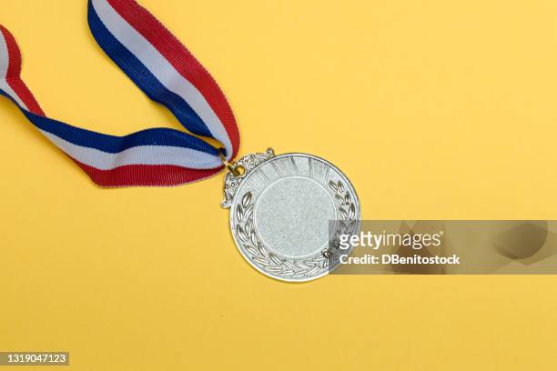 silver medal of sporting achievement for the second classified, on yellow background. - golden medals of merit in work ceremony stock pictures, royalty-free photos & images