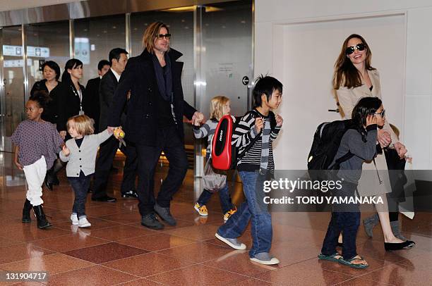 Accompanied by their children, US movie stars Brad Pitt and Angellina Jolie appear before photographers upon their arrival at Haneda Airport in Tokyo...