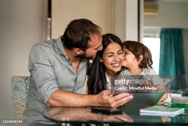 happy family sharing time together while sitting at home using digital tablet - day 5 imagens e fotografias de stock