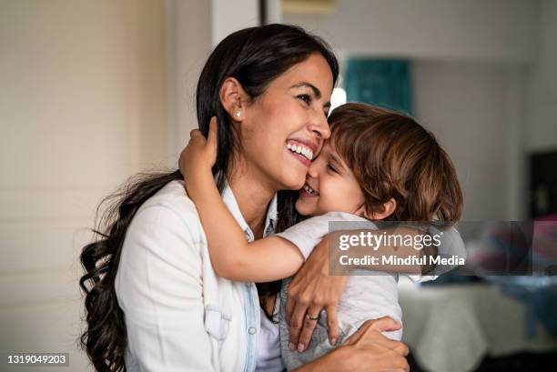 mother and son embracing each other at home - woman son stock pictures, royalty-free photos & images