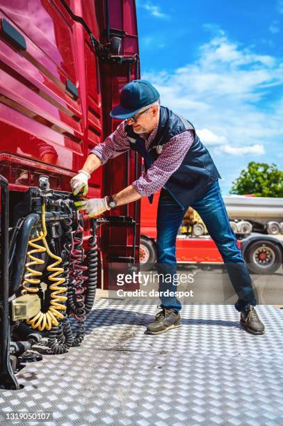 de vrachtwagenchauffeur controleert de juistheid van de truck - vrachtwagen banden stockfoto's en -beelden