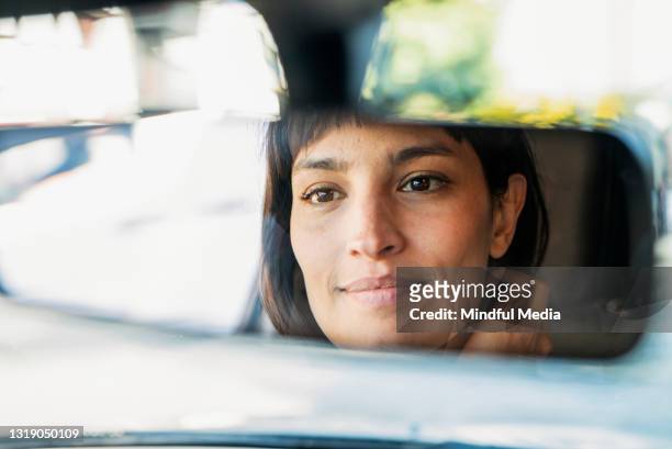 close-up of woman´s reflection on car´s rear view mirror - rear view mirror stock pictures, royalty-free photos & images
