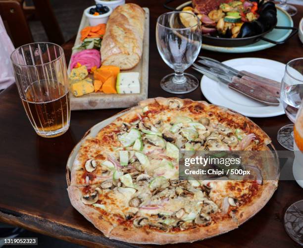 high angle view of pizza on table,kelowna,british columbia,canada - kelowna stock pictures, royalty-free photos & images