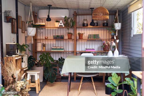 cozy place of work with bookshelves and plants - alpendre imagens e fotografias de stock