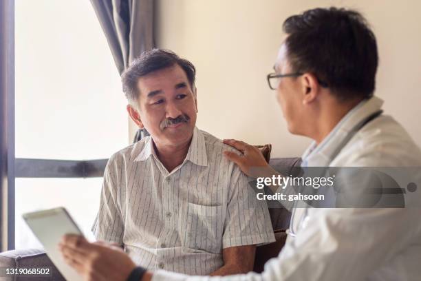 arts geruststellend ondersteunen senior patiënt in het ziekenhuis - male doctor man patient stockfoto's en -beelden