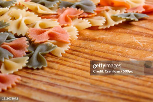 close-up of raw pasta on table - bow tie pasta stock pictures, royalty-free photos & images