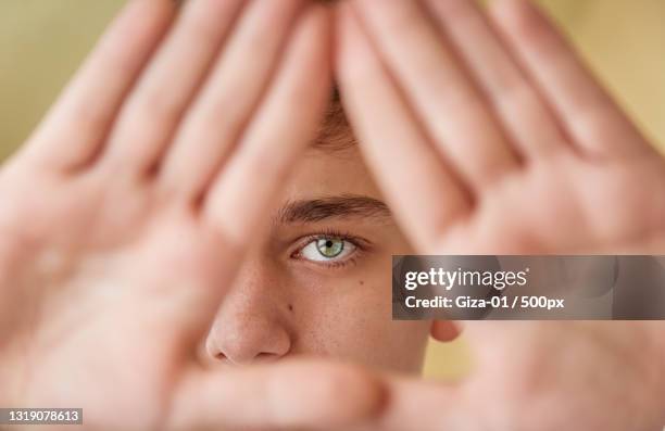 close-up portrait of eye with hands in the shape of a triangle - dreieck stock-fotos und bilder