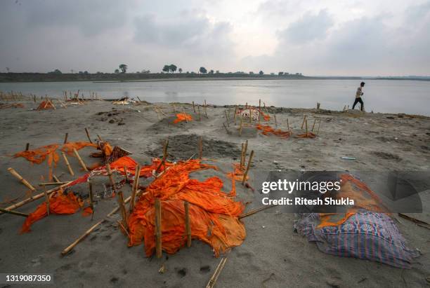 Bodies, some of which are believed to be Covid-19 victims, are seen partially exposed in shallow sand graves after rains washed away the top layer of...