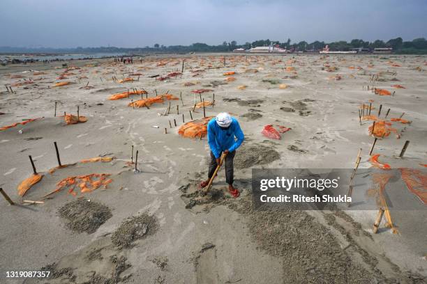 Bodies, some of which are believed to be Covid-19 victims, are seen partially exposed in shallow sand graves after rains washed away the top layer of...