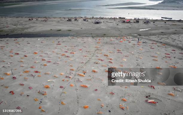 Bodies, some of which are believed to be Covid-19 victims, are seen partially exposed in shallow sand graves after rains washed away the top layer of...