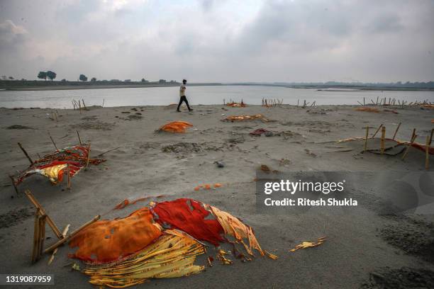 Bodies, some of which are believed to be Covid-19 victims, are seen partially exposed in shallow sand graves after rains washed away the top layer of...