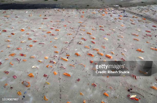 Bodies, some of which are believed to be Covid-19 victims, are seen partially exposed in shallow sand graves after rains washed away the top layer of...
