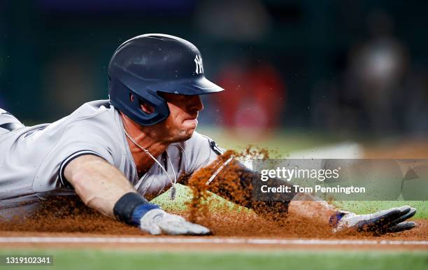 Brett Gardner of the New York Yankees slides safe into third base on a wild pitch by Dane Dunning of the Texas Rangers in the top of the fourth...