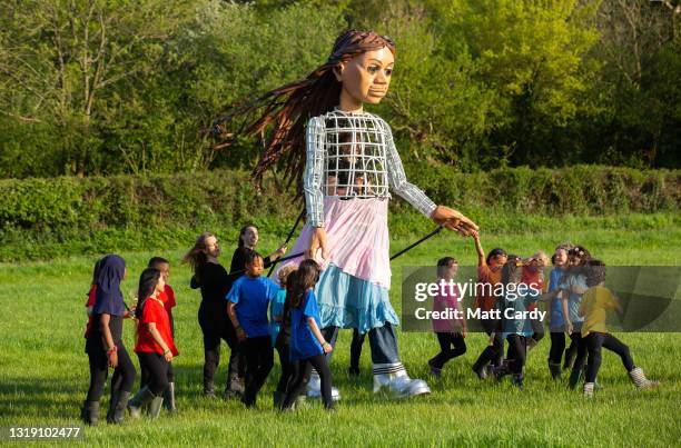 In this image released on May 21st, the puppet Little Amal performs as part of the Glastonbury Festival Global Livestream “Live at Worthy Farm” at...