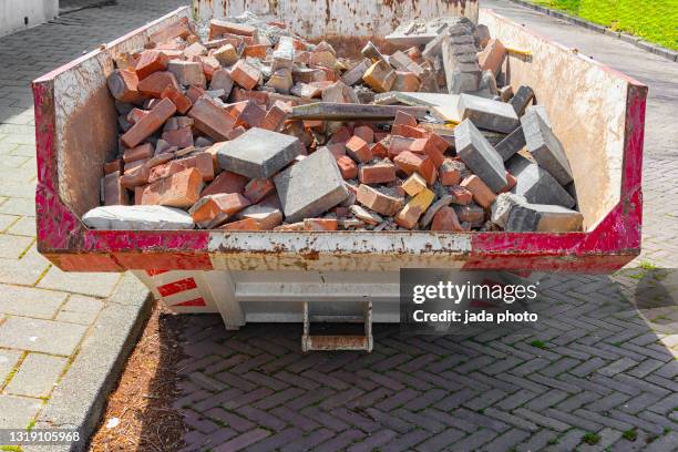 steel construction container filled with stone waste parked on the street - escombros material imagens e fotografias de stock