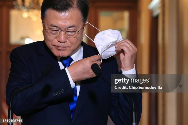 Korean President Moon Jae-in removes his face mask before delivering remarks with Speaker of the House Nancy Pelosi in her offices at the U.S....
