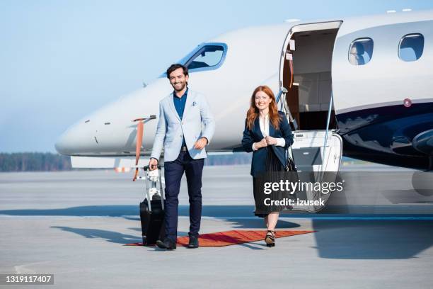 confident colleagues disembarking private jet - private aeroplane stock pictures, royalty-free photos & images
