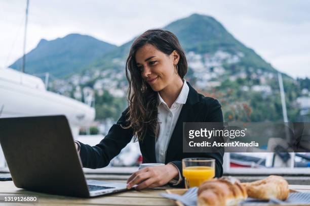 young business woman works remotely at an outdoor cafe - continental breakfast stock pictures, royalty-free photos & images