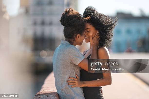 lesbisch paar kussen op de mond buitenshuis - kissing stockfoto's en -beelden