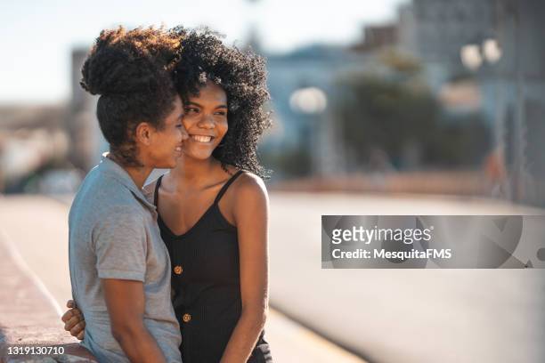 junges frauenpaar in der stadt an einem sonnigen tag - gay kiss stock-fotos und bilder
