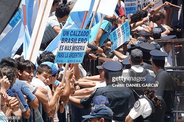 Shoe manufacturers demonstrate in front of police 18 December, 2001 in Buenos Aires. The workers where protesting the severe economic reforms imposed...