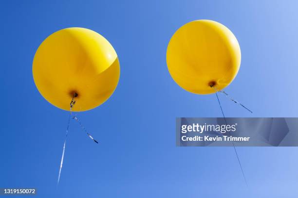 large yellow balloons in sky - helium stock pictures, royalty-free photos & images