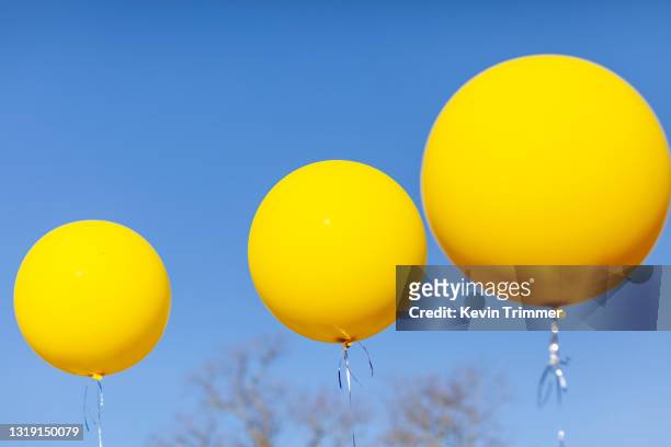 large yellow balloons in sky - dream big foto e immagini stock