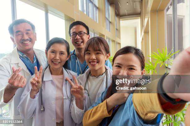 smiling team of doctors and nurses at hospital taking selfie - doctor humor stock pictures, royalty-free photos & images